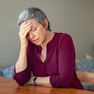 sitting-at-table-with-headache-sq
